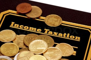 Book of  "Income Taxation" and coins isolated on white